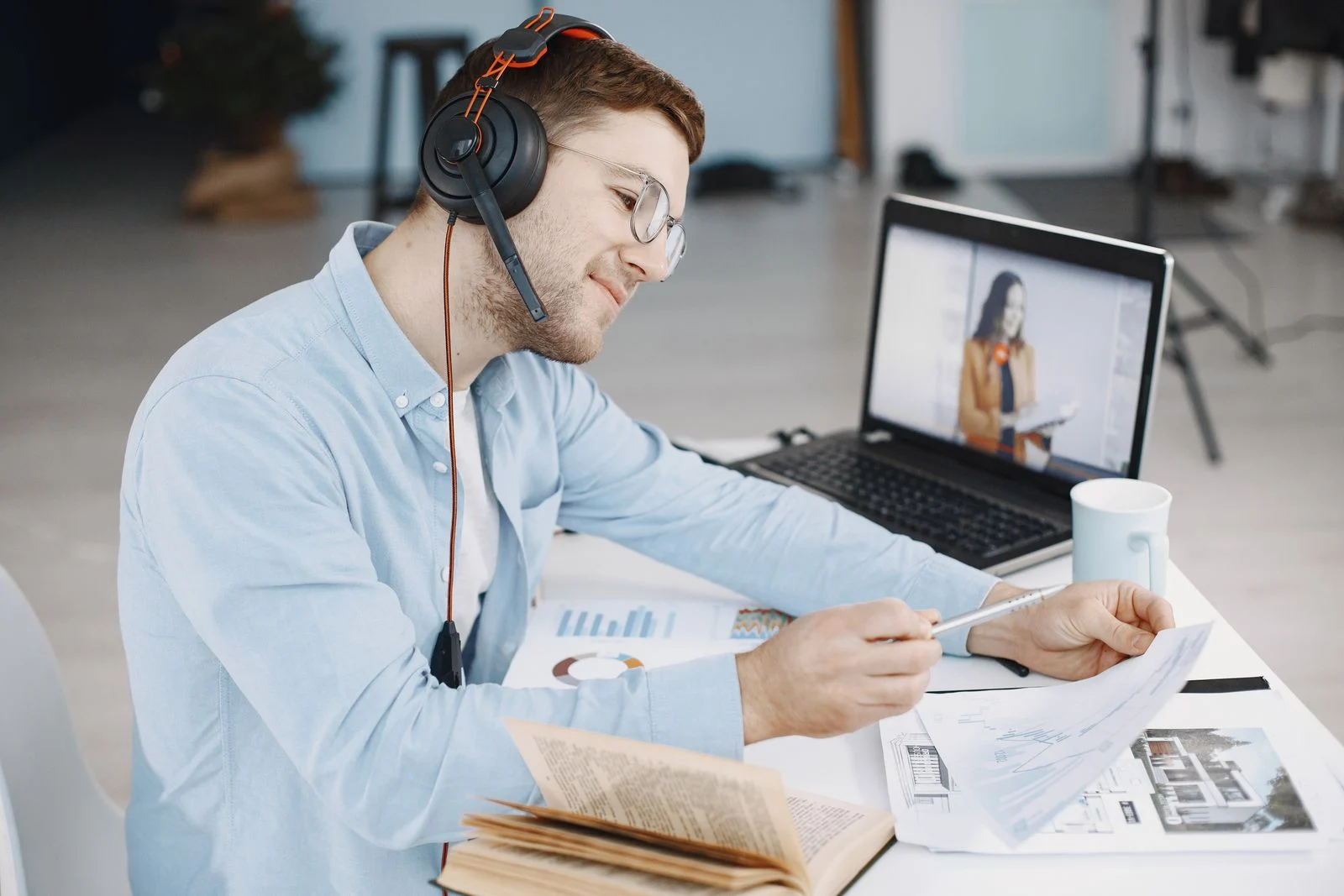 A man on a headset in a video call at his desk