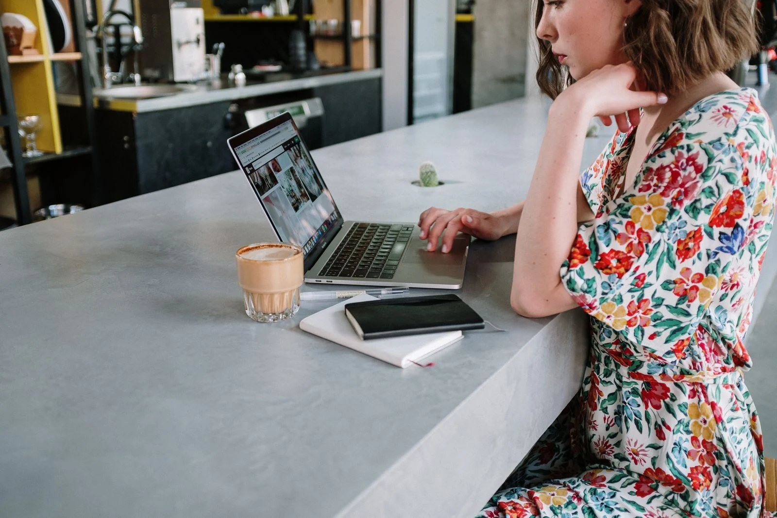A customer on a laptop at a cafe counter