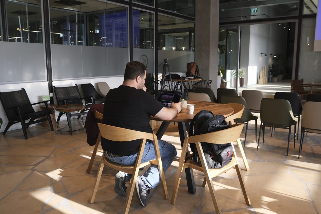 A man working on his laptop at a café table