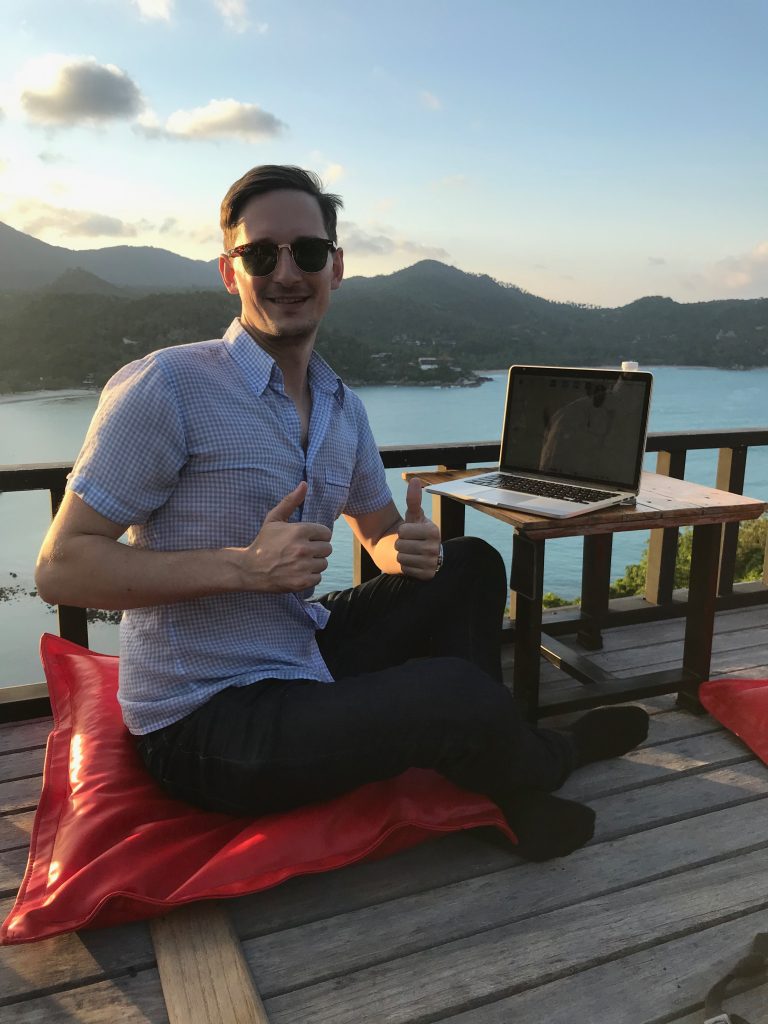 A man on a video call from a deck by the water