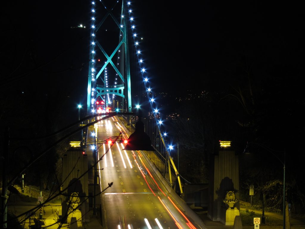 Lions Gate Bridge in Vancouver at night, traffic light trails crossing it