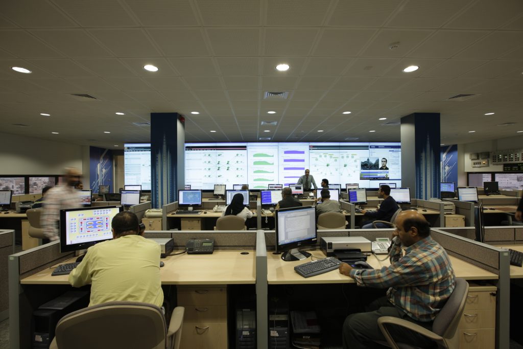 Engineers at a network operations centre with a wall of screens