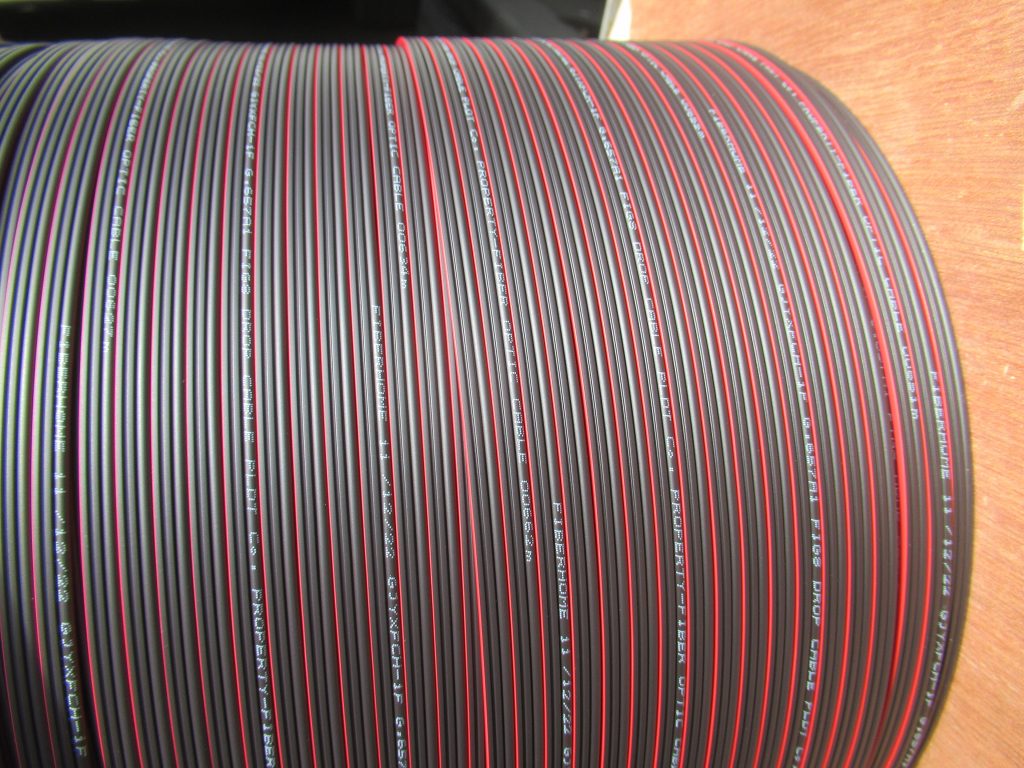 A reel of black fibre cable with red stripes