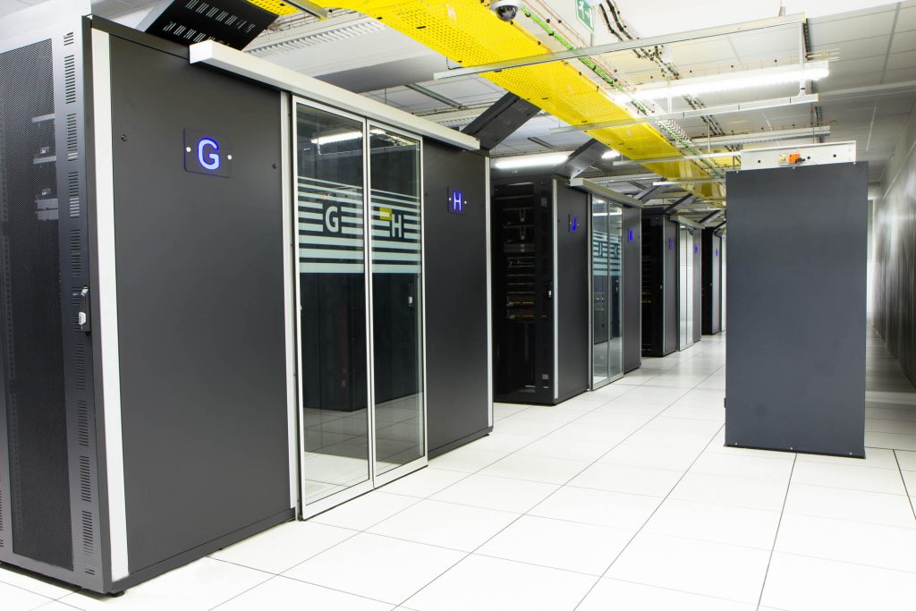 Rack cabinets behind glass doors along a corridor