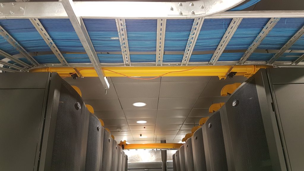 Overhead cable trays and a fibre duct above the racks