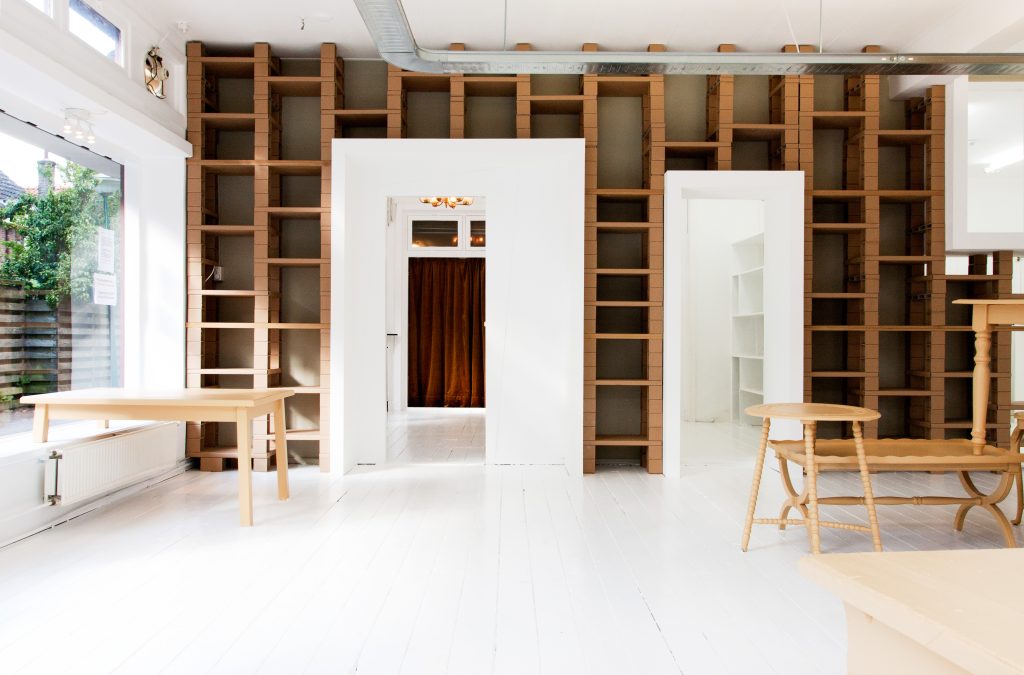 An empty white room with bare wooden shelves
