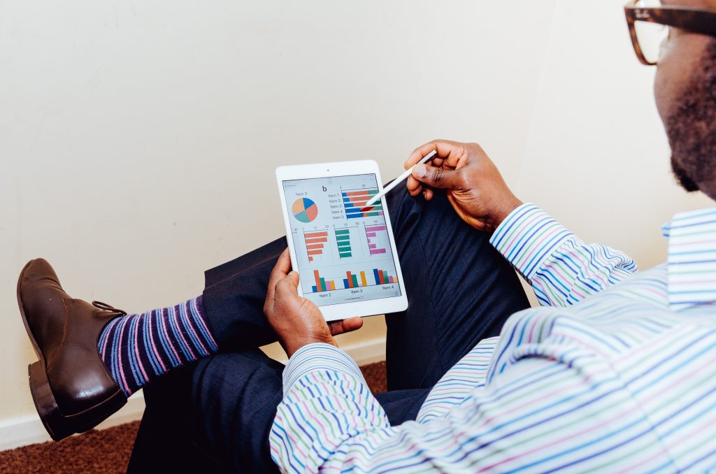 A man in a suit reading on a tablet