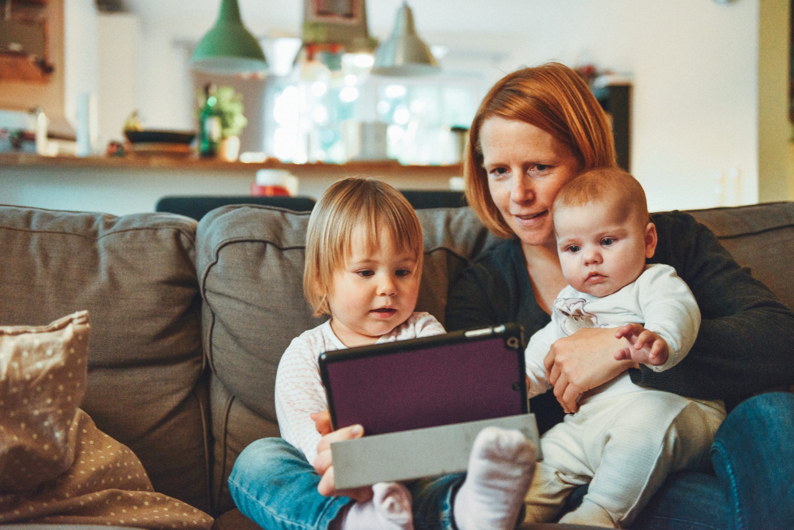 A family on a couch looking at a tablet together