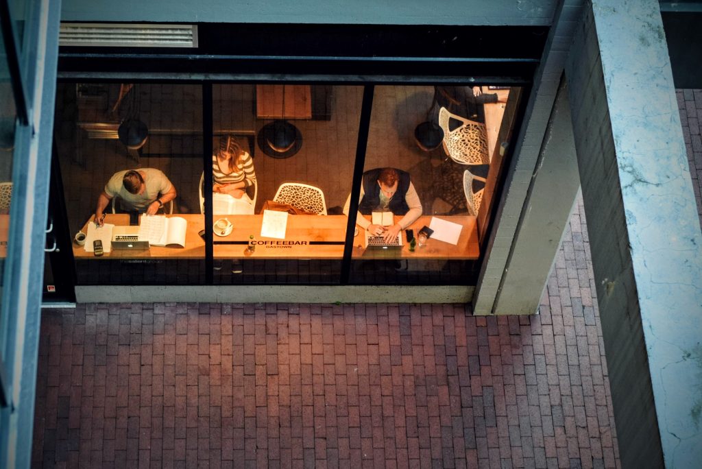 People working at the window of a coffee shop at night