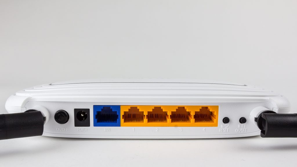 The back of a home router with its yellow network ports and a blue internet port